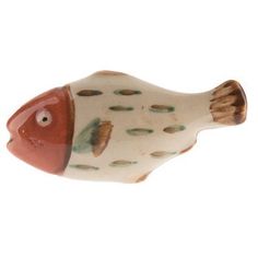 a ceramic fish figurine is shown against a white background with brown spots on it's body