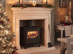 a fire place in a living room next to a christmas tree with candles on it