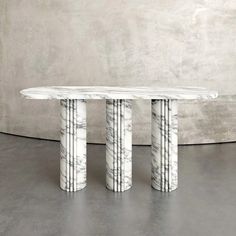 an oval marble table with three columns in the middle