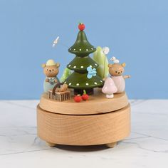 a small wooden box with a christmas tree on it and two mice in front of it