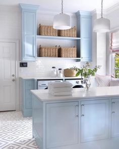 a kitchen with blue cabinets and white counter tops