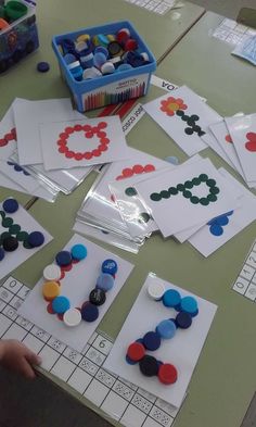 a table topped with lots of different types of buttons and paper on top of it