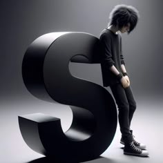 a young man leaning on the letter s