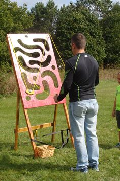 a man standing next to a little boy in front of an easel with a painting on it