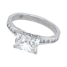 a white gold ring with a princess cut diamond