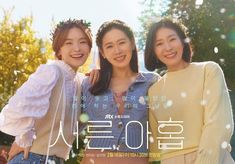 three young women standing next to each other in front of trees and snow flakes