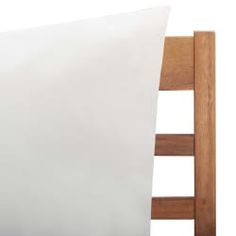 a white pillow sitting on top of a wooden bed frame