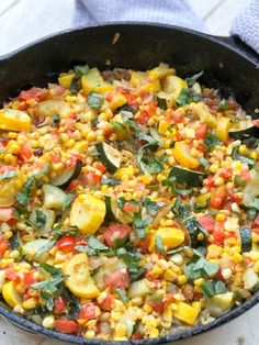 a skillet filled with corn and vegetables