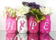 pink and white painted mason jars with flowers in them