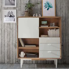 a white cabinet with drawers and pictures on the wall