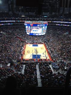 an indoor basketball game in progress with the crowd looking on from the upper level balcony