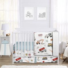 a baby crib bedding set with trucks and cars on it in a nursery