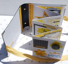 the inside of an open book with yellow and white trimmings, on top of a table