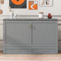 a grey cabinet with two doors and some pictures on the wall