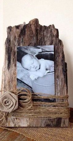 an old wooden frame with a baby's photo on it and twine around the edges