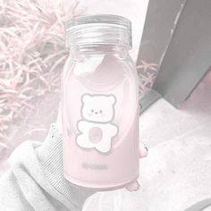 a person holding a pink bottle with a bear on it