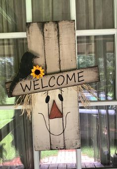 a wooden welcome sign with a sunflower on it's head and the words welcome