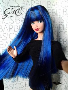 a doll with long blue hair is posed in front of a white and black wall