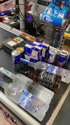 an assortment of drinks and snacks are on the counter at a grocery store in front of other items