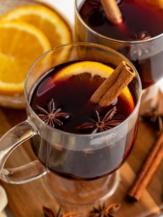 two glasses of mulled with cinnamon and orange slices