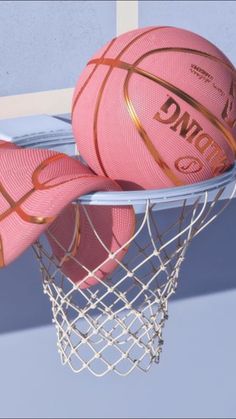 two pink basketballs sitting on top of a net