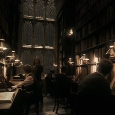 people sitting at tables in an old library