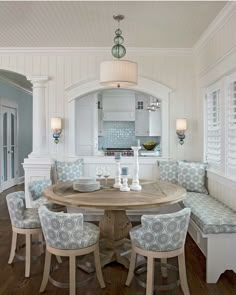 a dining room table surrounded by blue and white chairs