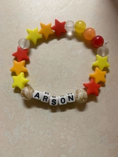 a bracelet with the word aaron spelled in letters and stars on it, sitting on a table