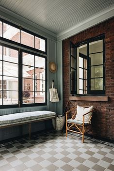 a bench sitting in front of two large windows