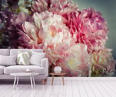 a living room with a couch, coffee table and large flower mural on the wall