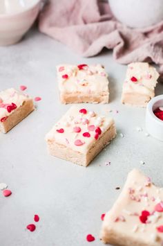 several pieces of cake with white frosting and red sprinkles