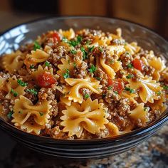 a bowl filled with pasta and meat on top of a table