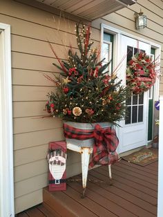 a potted christmas tree on the front porch