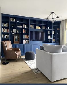 a living room with blue bookcases and white furniture