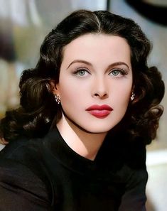 a close up of a person wearing a black shirt and red lipstick on her face