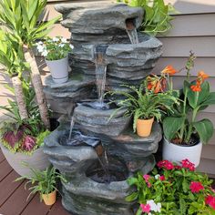 an outdoor fountain surrounded by potted plants