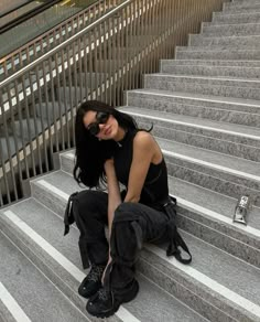 a woman sitting on some stairs with her legs crossed