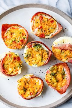 several deviled eggs on a plate with cheese and seasoning sprinkles