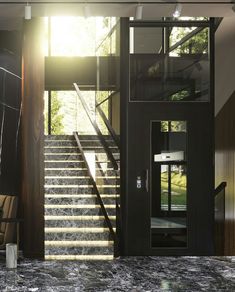 an open staircase leading to the upper level of a house with glass walls and doors