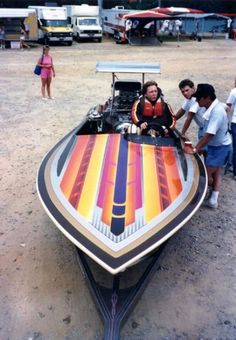 a group of people standing around a colorful boat