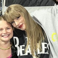 two young women standing next to each other with their arms around one another and smiling at the camera