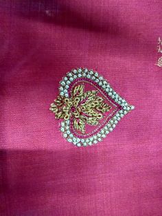 an embroidered pink fabric with gold and green accents