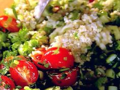 a salad with tomatoes, cucumbers, and other vegetables is ready to be eaten