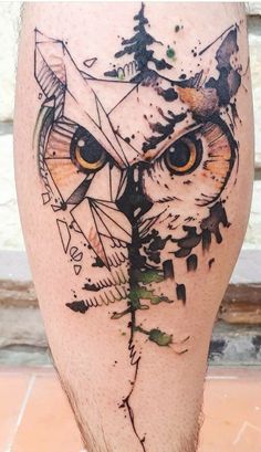 an owl tattoo on the leg with trees and arrows in it's eyes is shown