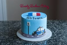 a birthday cake with a police car design on the top and name written on it