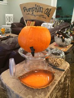 a pumpkin sitting on top of a glass bowl filled with liquid next to other items