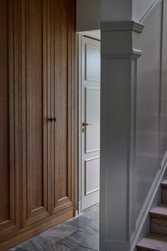 an open door and some stairs in a house with wood paneling on the walls