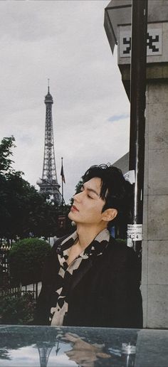 a man standing next to a pole with the eiffel tower in the background