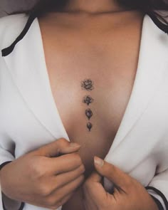 a woman is showing off her chest with three flowers on the left side and four petals on the right side