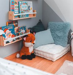 a stuffed animal sitting on top of a bed next to a book shelf